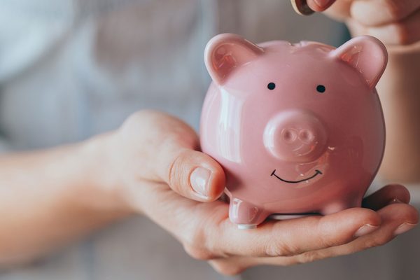 Person holding a pink piggy bank