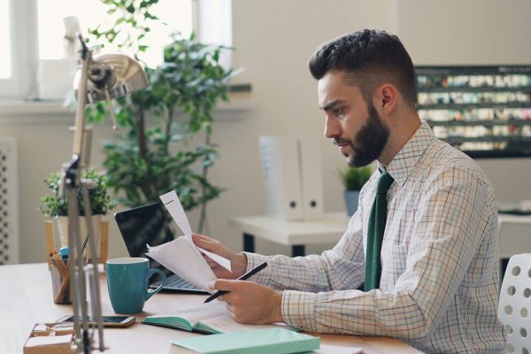 Estate agent working at his desk, reading some notes