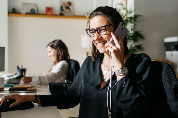 business woman smiling taking a call at her desk