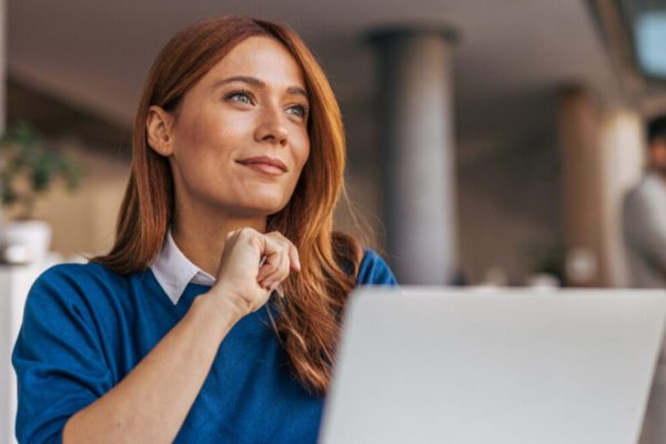 Business woman glancing away in front of her laptop