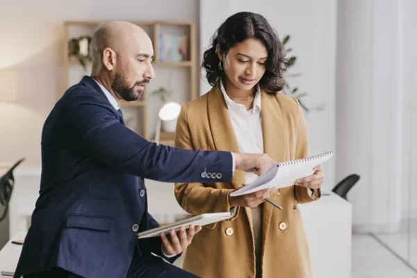 Two real estate agents in an office, working and looking at a report