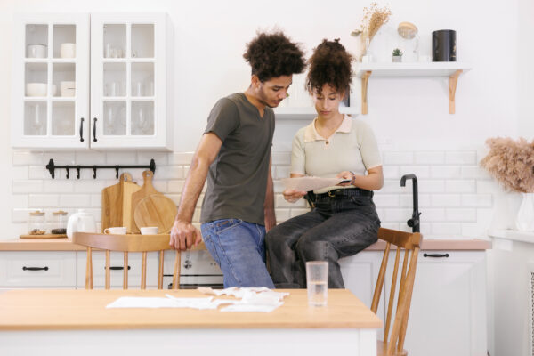 Couple Man Woman Are Sitting On Table In Kitchen Paying Electricity And Rent Bills.