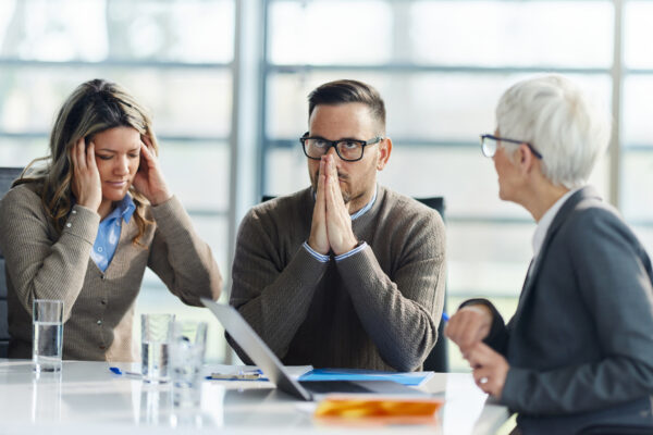 Frustrated Couple Having A Meeting With Insurance Agent In The Office.