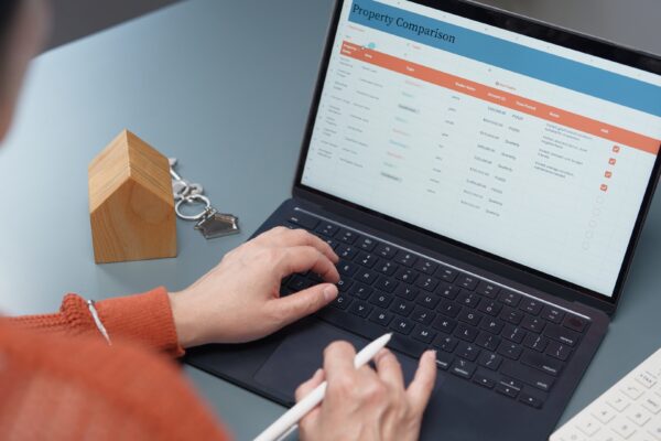 Real estate agent compares multiple real estate listings on a laptop