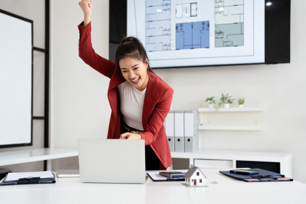 Excited real estate agent sit at desk overjoyed