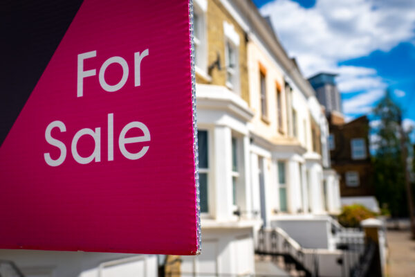 Estate agent 'For Sale' sign outside a UK home