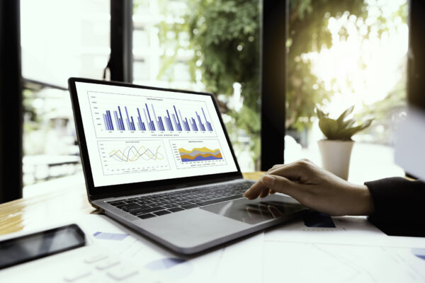 Person working with graphs and charts on a laptop